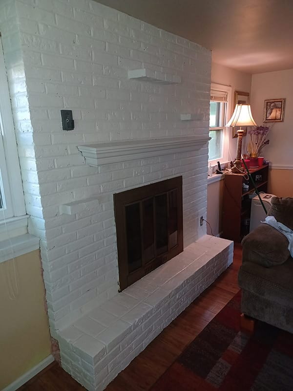 Modern white painted brick fireplace and hearth in living area