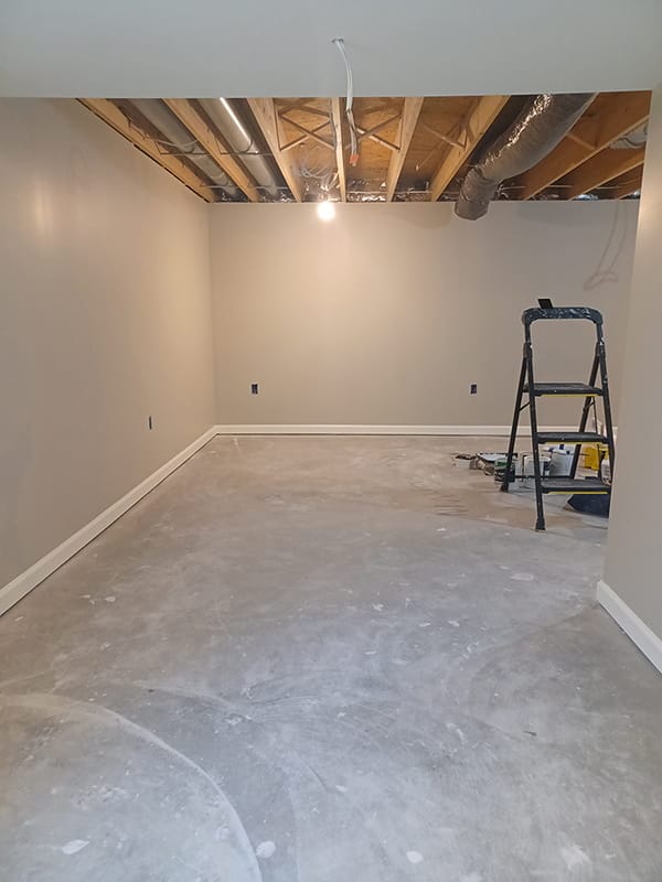 Empty basement room with freshly painted walls and concrete floor