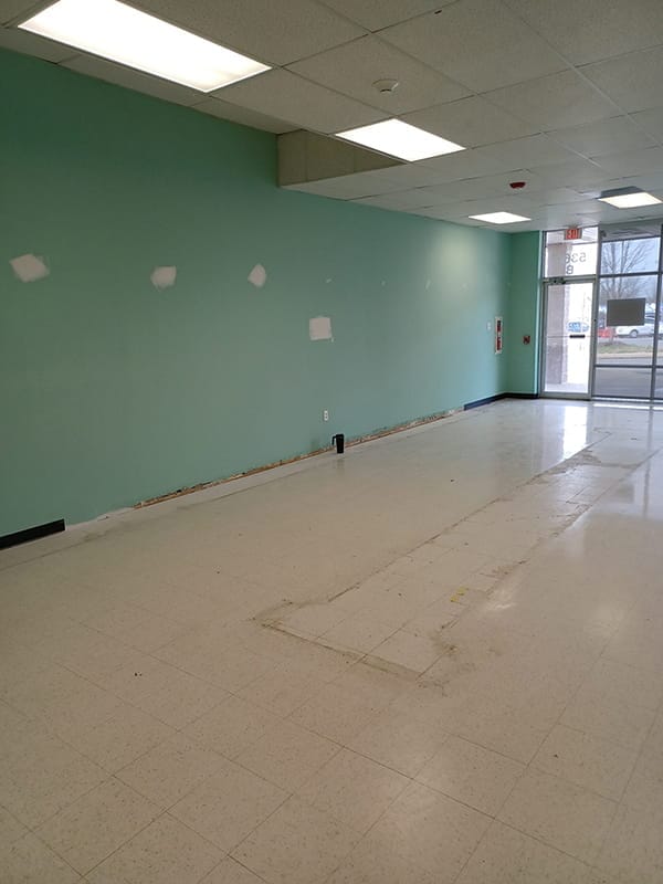 Green commercial interior wall with spackled drywall patch repairs