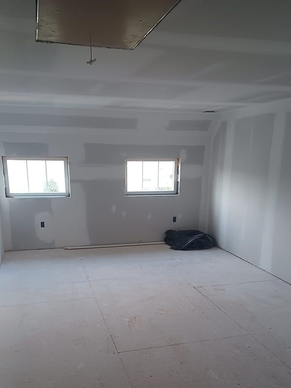 Unfinished interior room with taped drywall and subflooring