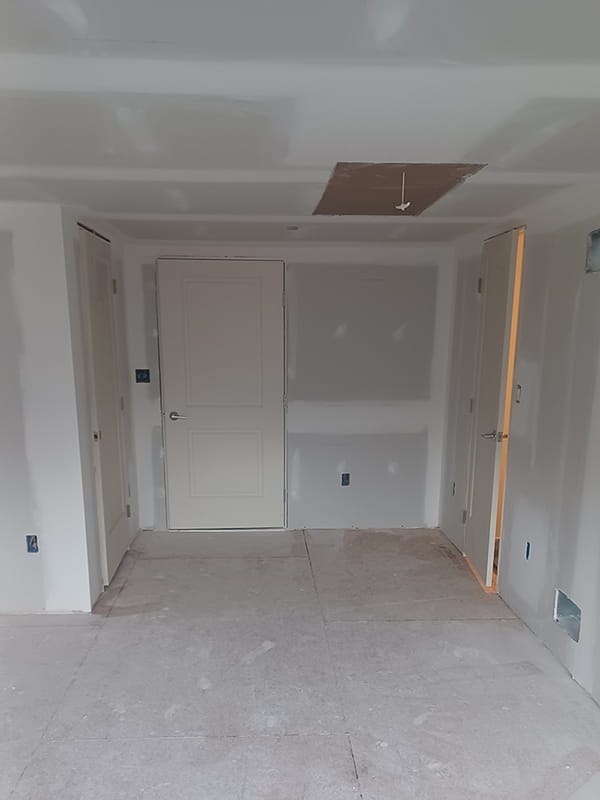 Basement room with repaired drywall ready for painting