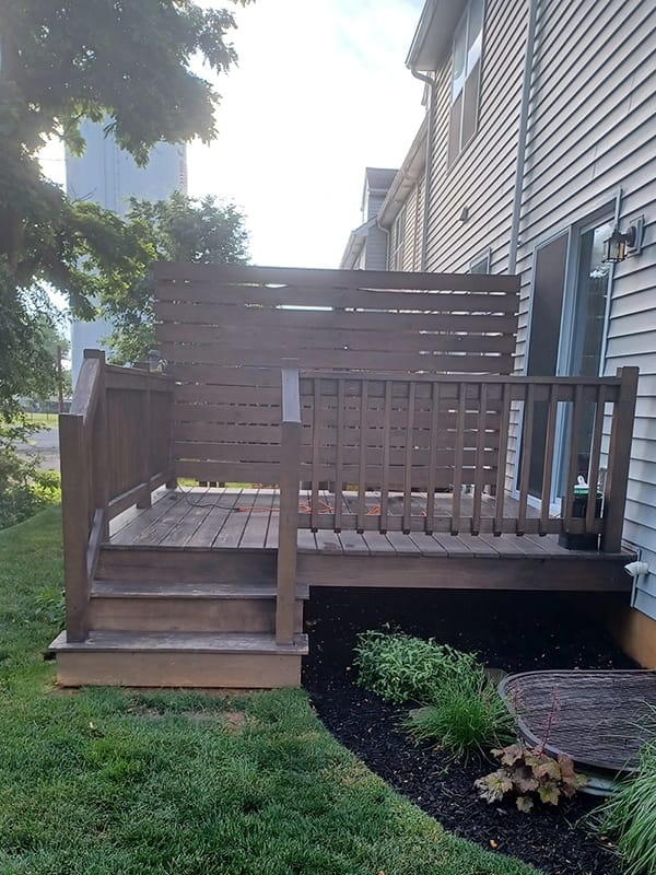Weathered backyard deck with privacy wall before refinishing
