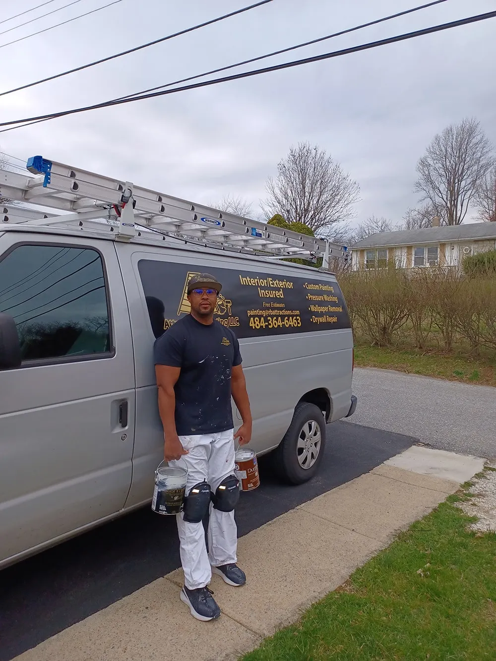 Professional painter standing beside company work van